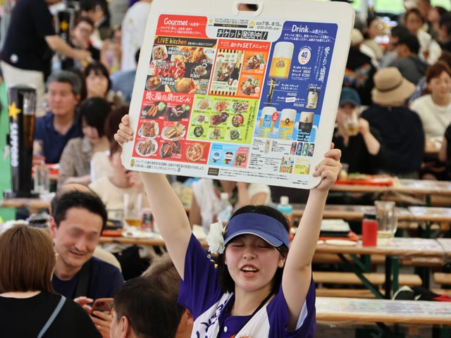 THE サッポロビヤガーデン、メニュー看板を持って注文を受ける女性